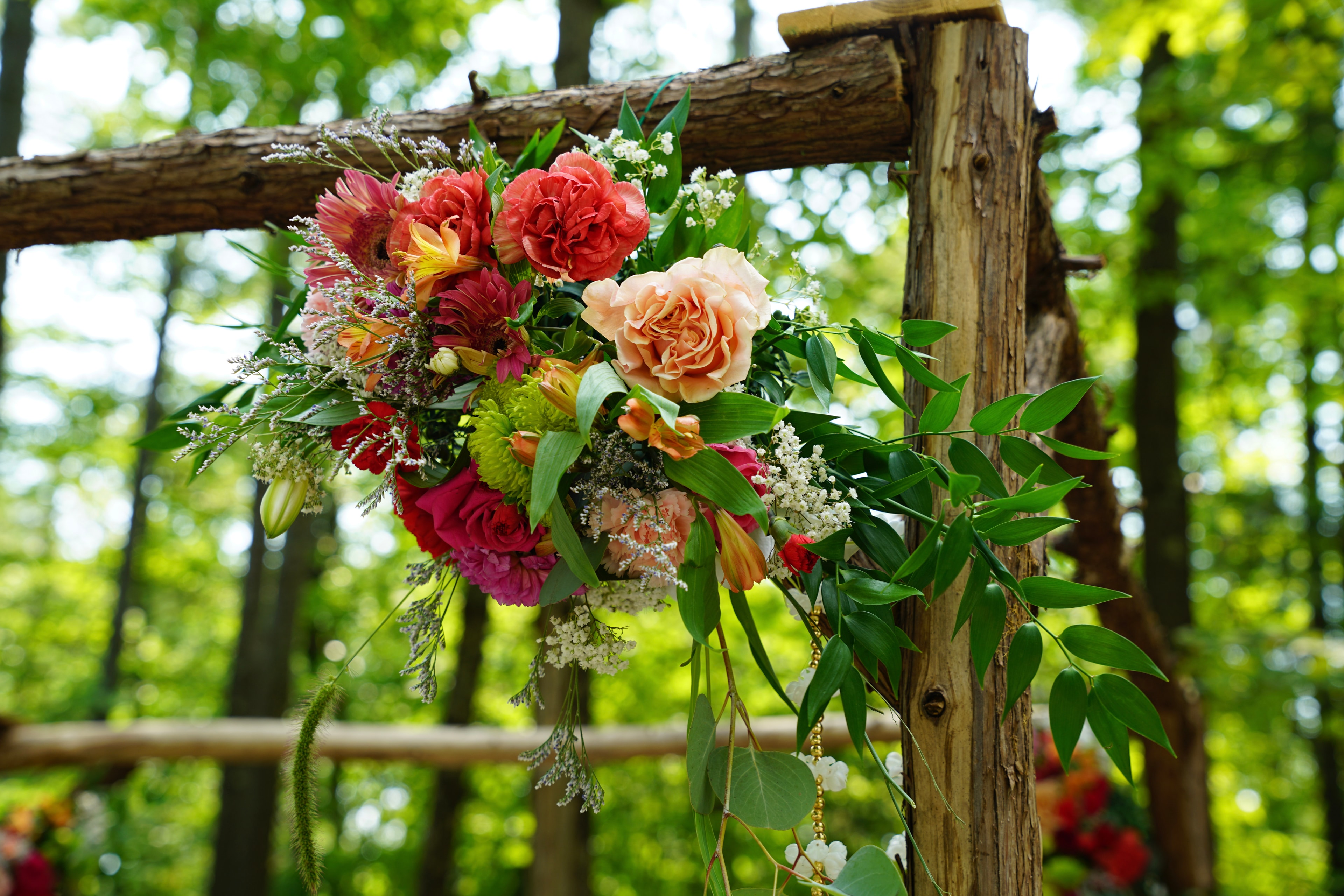 Colourful floral arrangement on a rustic wooden structure in the forest